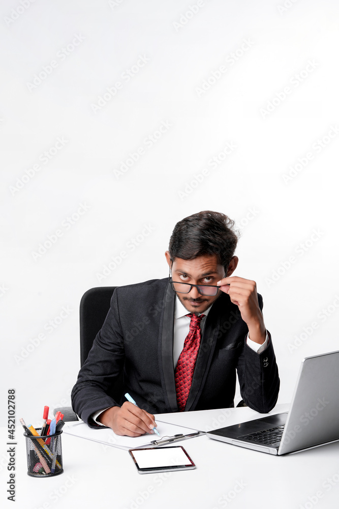 Young indian man in suit and working on laptop and writing some Young indian man in suit and working on laptop and writing some