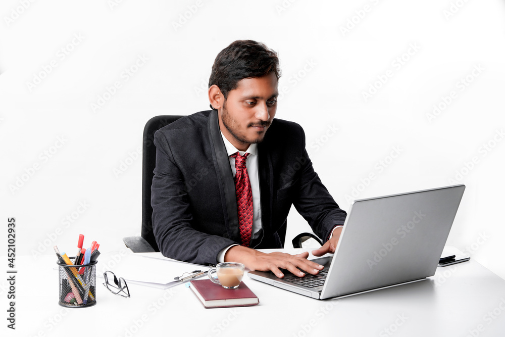 Young indian man in suit and working on laptop at office Young indian man in suit and working on laptop at office