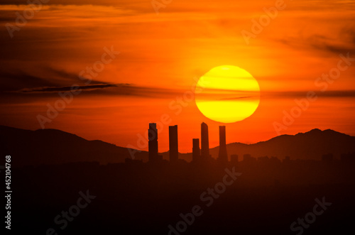 Panoramic of the business area of the four towers of Madrid with the sun setting behind photo