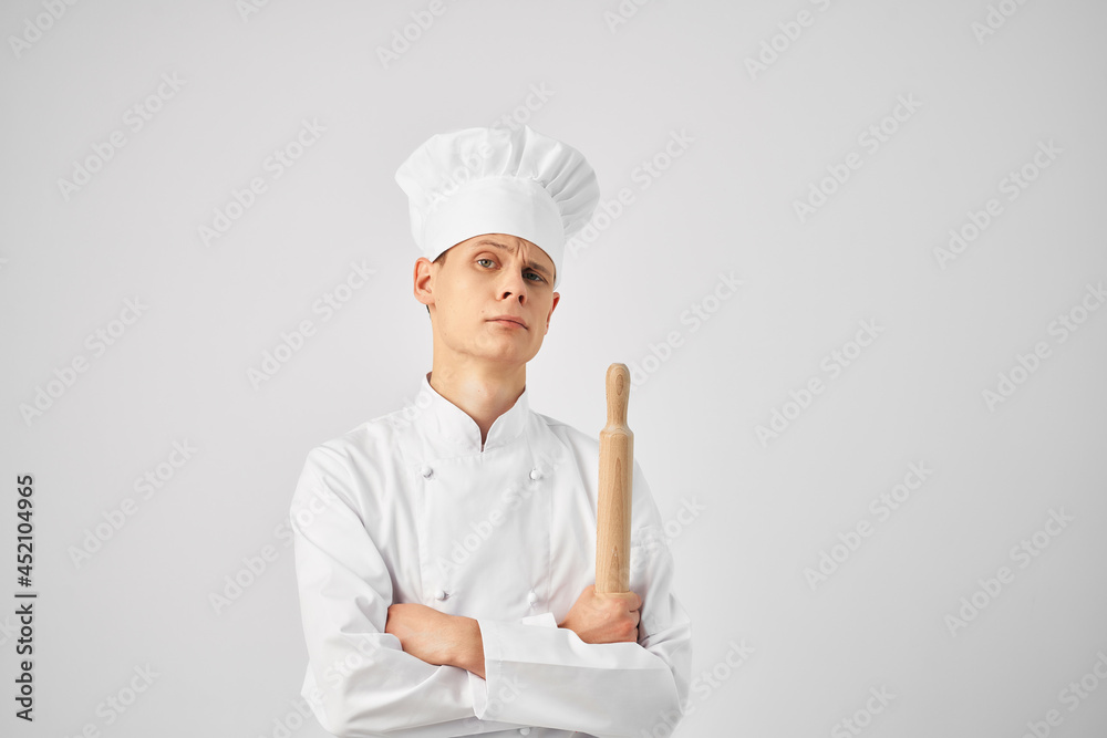 Cheerful chef in the uniform of a rolling pin in the hands of a restaurant Cheerful chef in the uniform of a rolling pin in the hands of a restaurant