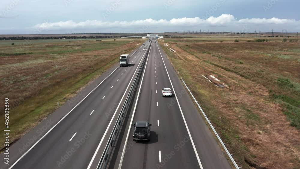 Cars and trucks are traveling on the expressway. Top view. Aerial video shooting. Cloudy weather. A modern highway. Cars and trucks are traveling on the expressway. Top view. Aerial video shooting. Cloudy weather. A modern highway.