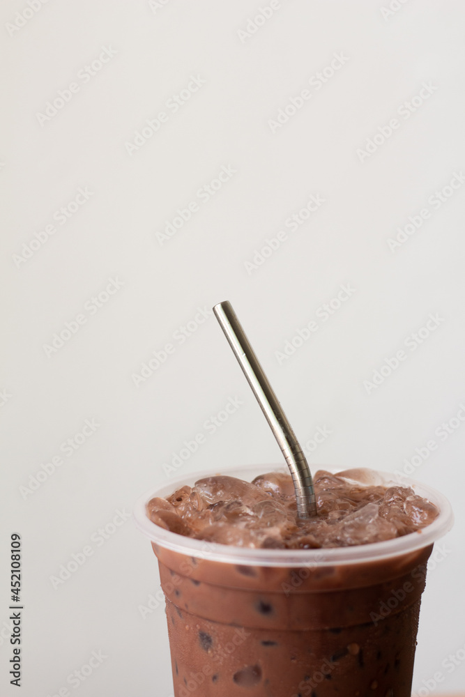 Close up reusable stainless steel straw with iced chocolate on white background. Close up reusable stainless steel straw with iced chocolate on white background.
