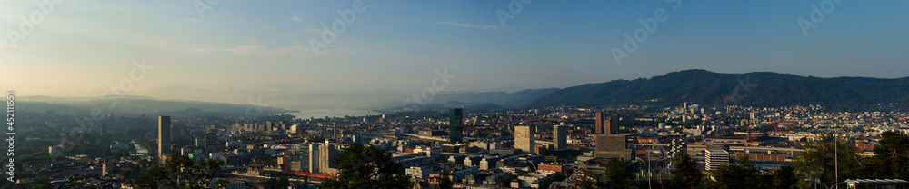Large panorama of the city of Zurich in the morning with a blue sky from the Waid. With Prime Tower, Uetliberg and Lake Zurich. 