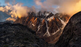 Majestic glacier is illuminated by the bright golden evening sun. Panoramic view. Altai Mountains.