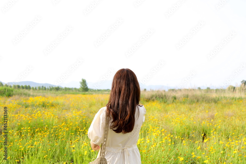 A woman standing on a yellow flower field