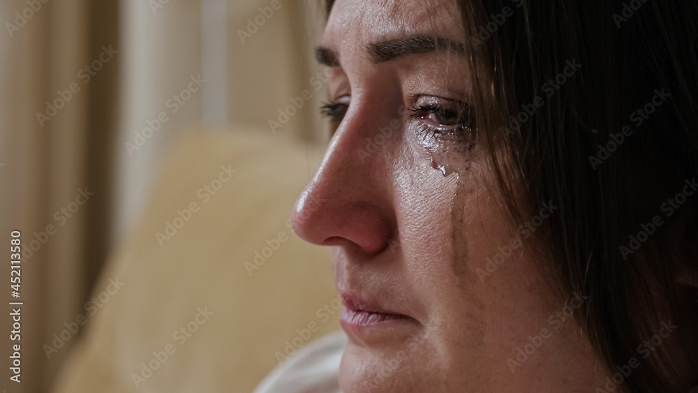Close-up of a crying young woman with blurry mascara dripping down her cheeks. Close-up of a crying young woman with blurry mascara dripping down her cheeks.