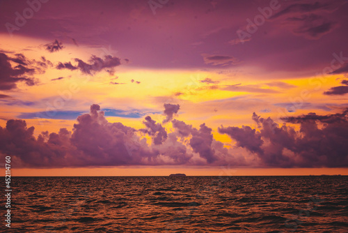 Nature in twilight period which including of sunrise over the sea and the nice beach. Summer beach with blue water and purple sky at the sunset.	
