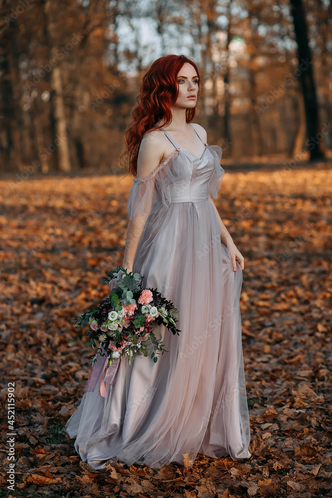 Portrait of young redhead woman in autumn yellow park