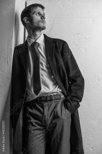 Young confident caucasian man in suit in black and white. Business concept