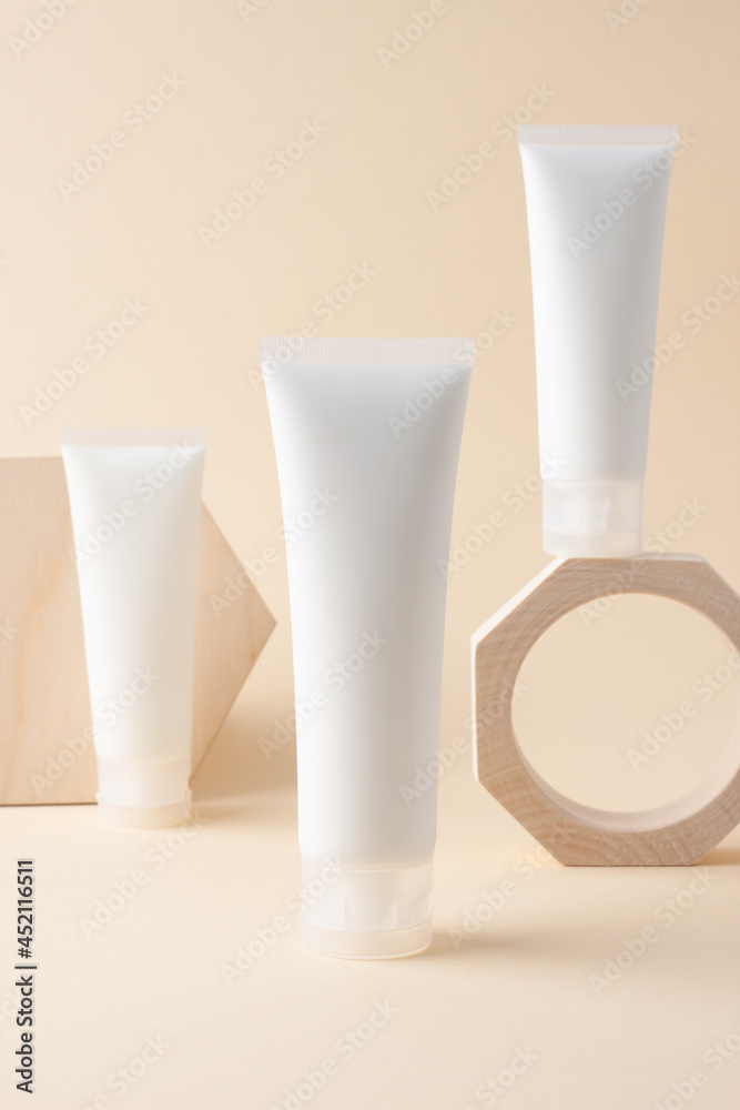 White tube of cosmetic cream on podium on beige background. Close up.