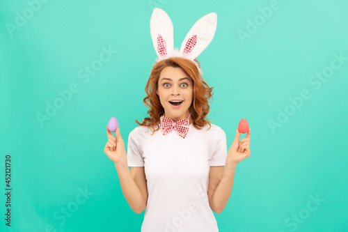 surprised redhead woman in bunny rabbit ears with painted eggs, happy easter