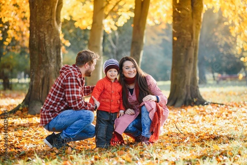 happy family mother father and baby on autumn walk in the park