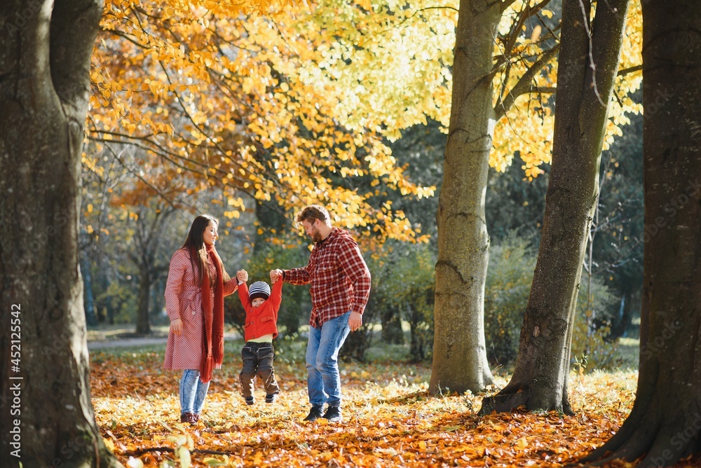 Young family walking in the park. Autumn.