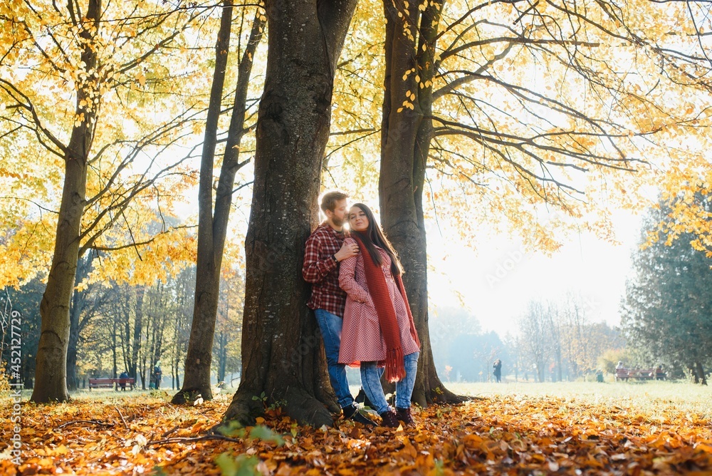 Young couple in love walking in the autumn park holding hands Young couple in love walking in the autumn park holding hands