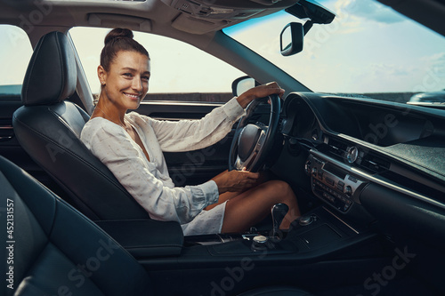 Joyful woman is turning car steering wheel © Viacheslav Yakobchuk
