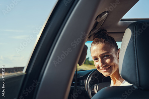 Middle-aged female peeking at back seats from driver place © Viacheslav Yakobchuk
