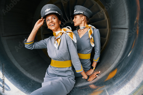 Принти на полотні Air hostesses in pilot caps sitting in the turbofan engine