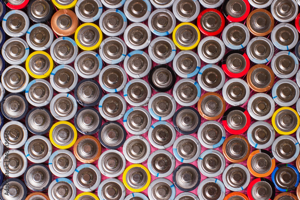 alkaline batteries on top of each other on a red background alkaline batteries on top of each other on a red background