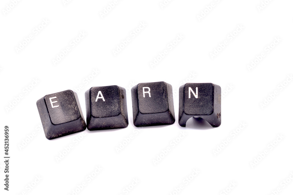 text Earn. Business concept. Dirty used keyboard buttons on white background, finance concept text Earn. Business concept. Dirty used keyboard buttons on white background, finance concept