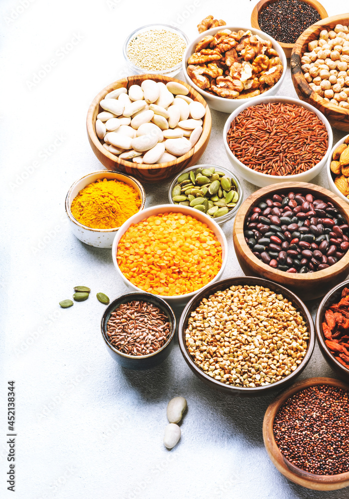 Set of superfoods, legumes, cereals, nuts, seeds in bowls on white table. Copy space, top view Set of superfoods, legumes, cereals, nuts, seeds in bowls on white table. Copy space, top view