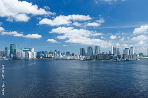 青空を背景にレインボーブリッジjから見た東京湾河口とウォーターフロントのビル群 © maruboland