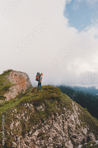 Backpacker climbing mountains travel adventure vacations outdoor active healthy lifestyle woman standing on cliff edge