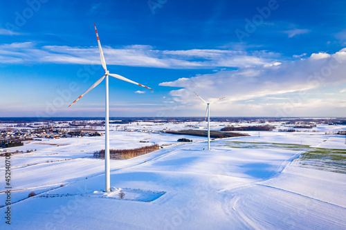 Snowy field and wind turbine. Alternative energy in winter.