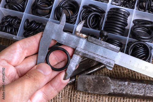 Measuring the diameter of the rubber ring with a caliper. A man is holding an old measuring instrument in his hands.