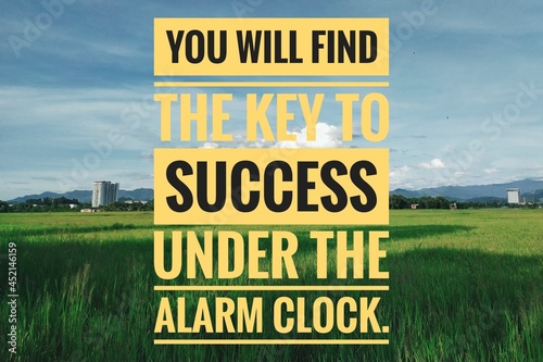 You will find the key to success under the alarm clock. Motivational quote isolated in paddy fields scenery.