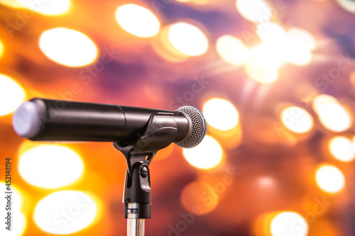 Microphone Public speaking background, Close-up the microphone on stand for speaker speech presentation stage performance with blur and bokeh light background.