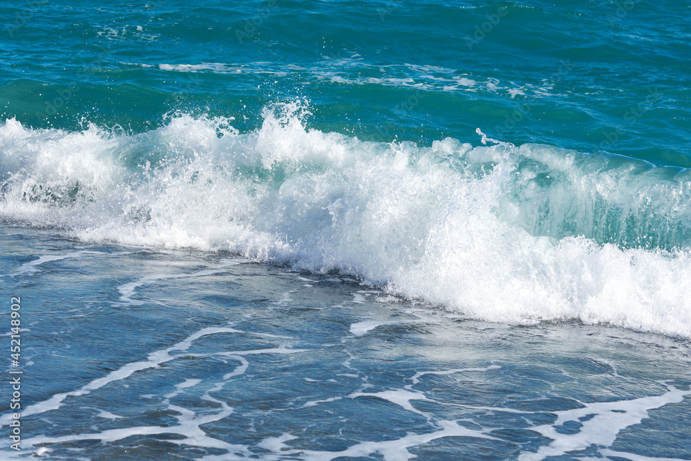 Turquoise sea close-up in bright sunlight.Colorful tropical background. The concept of summer, vacation, travel.The purest clear blue water, small waves roll on the sandy shore. The texture of the sea Turquoise sea close-up in bright sunlight.Colorful tropical background. The concept of summer, vacation, travel.The purest clear blue water, small waves roll on the sandy shore. The texture of the sea