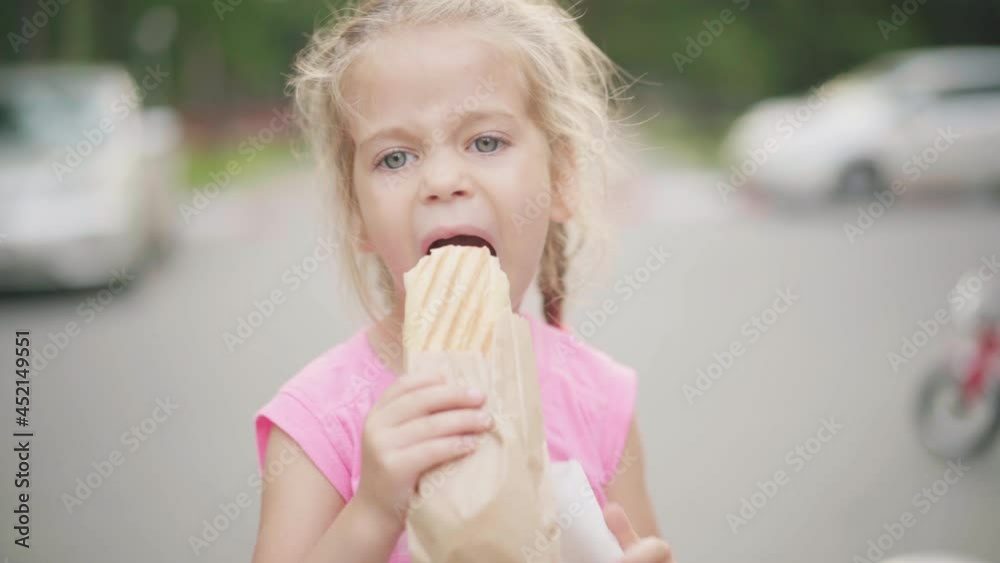 Little Girl Eat Hot Dog Summer Park Food And Drink Concept Caucasian Female Child Eating Street Food Close Up Portrait Kid bite Sandwich outside Little Girl Eat Hot Dog Summer Park Food And Drink Concept Caucasian Female Child Eating Street Food Close Up Portrait Kid bite Sandwich outside