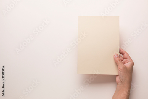 White booklet mockup. Female hands hold an empty blank. Blank form, mockup 