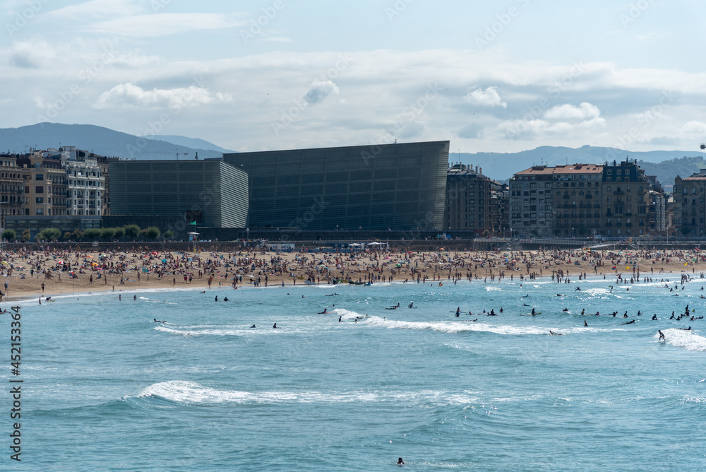 Naklejka premium Vista de la playa de la zurriola en San Sebastian en un dia de verano con gente bañandose
