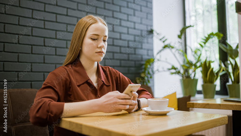 Young blond woman using smartphone app at coffee shop, mobile shopping, calling a cab Young blond woman using smartphone app at coffee shop, mobile shopping, calling a cab