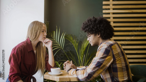 Fotografija Upset girlfriend sitting in silence with boyfriend in cafe, relationship crisis,