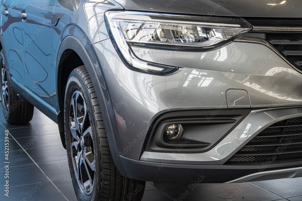 Renault Arkana gray SUV at Renault showroom. Close-up of right headlight, right front fog lamp and right front wheel. Renault car dealership in Mega Adygea. Krasnodar, Russia - August 17, 2021