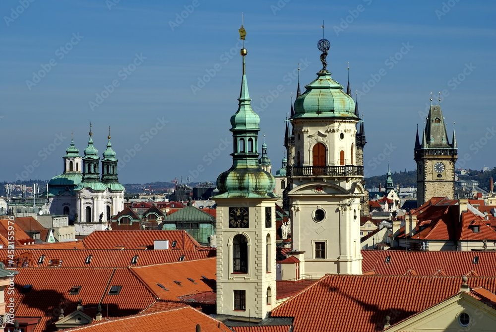 Overhead view of the red tile roof of buildings with churches protruding above in the Old  in Prague, Czech Republic