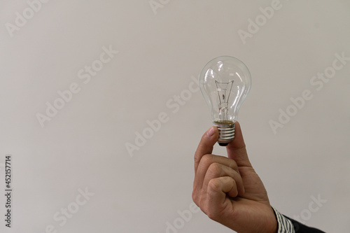 Digital composite image of a hand held light bulb, energy saving concept.