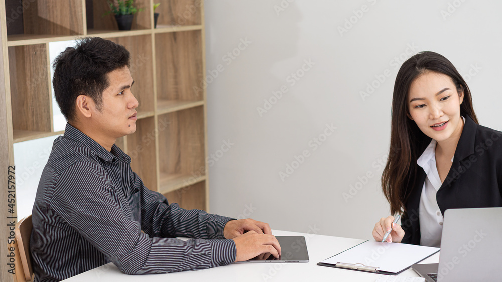 Young businessmen working together in the office with laptops and tablets folded papers on the desk.