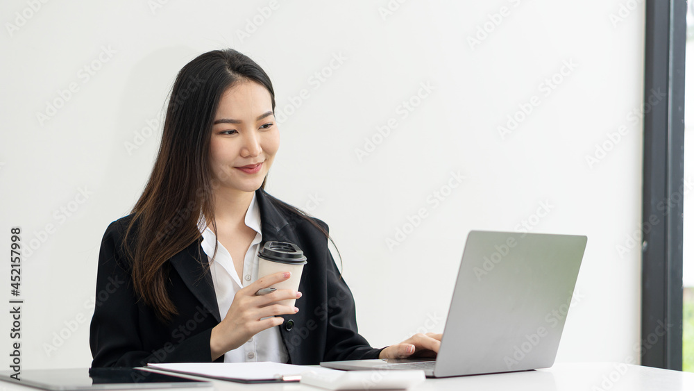 business woman working with laptop at desk with coffee mugs in office business woman working with laptop at desk with coffee mugs in office