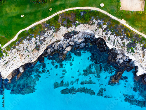 Aerial Top Drone view of turquoise crystal sea and green shore in Cyprus, landscape from above