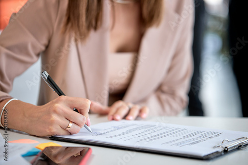 Close-up hand business lady signing financial contract, put write signature on legal corporate paper fill document form buy insurance loan, making business agreement, close up view. business concept