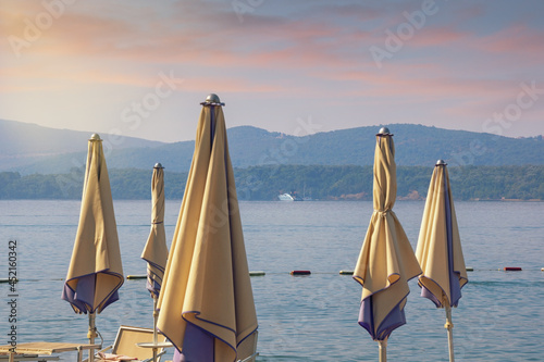 Beach vacation.  Beautiful Mediterranean landscape with beach umbrellas. Sunset. Montenegro, Adriatic Sea,  Bay of Kotor, Tivat photo