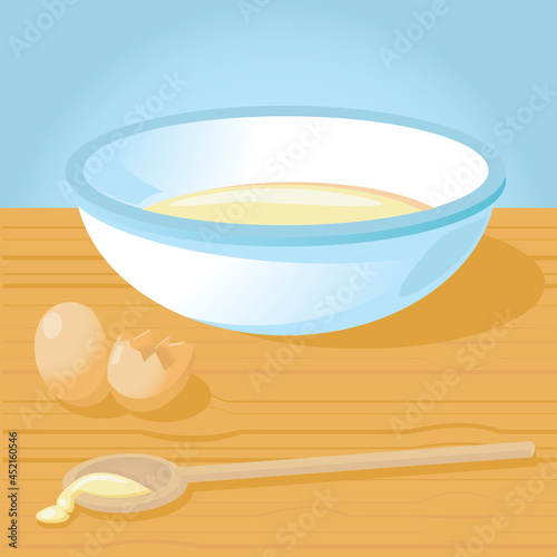 Enamel mixing bowl with cake mix or pancake batter, eggs & wooden spoon