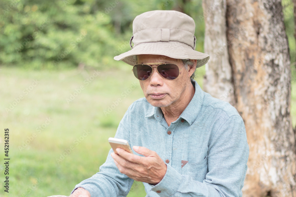 senior man wearing sunglasses holding a mobile phone in his hand
