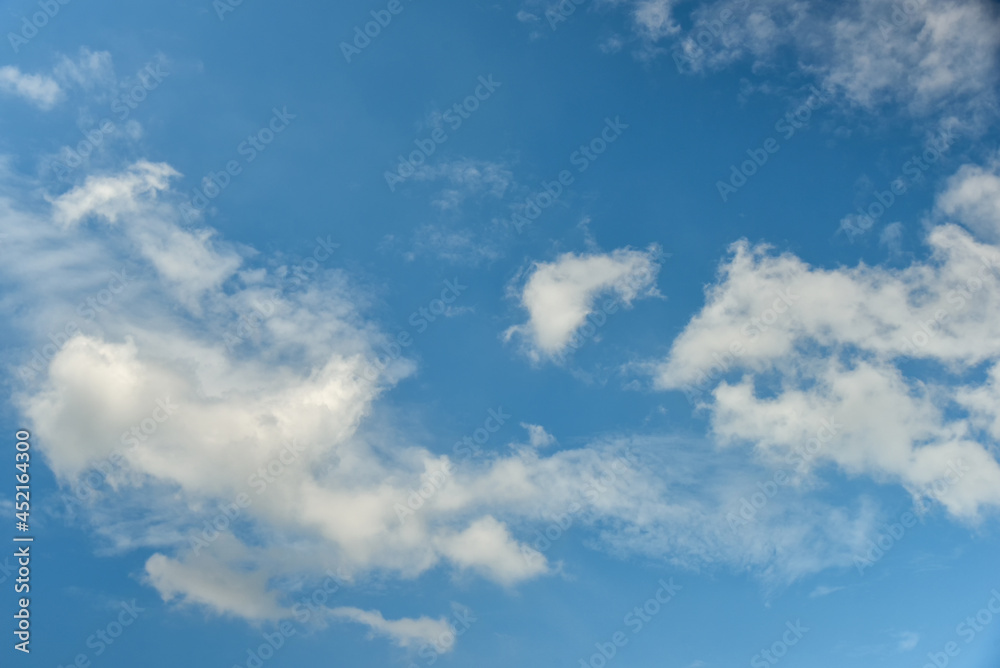 Beautiful cumulus clouds against the blue daytime sky.