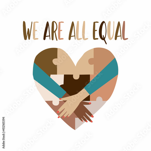 The concept of unity and against racism. The inscription We are all equal and a heart of different colors in the form of a puzzle that displays different skin colors. As well as female hands.