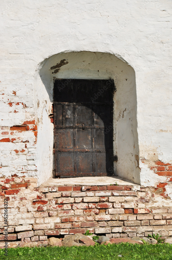 Steel door. A metal forged door in the wall of an old building. Ancient architecture.