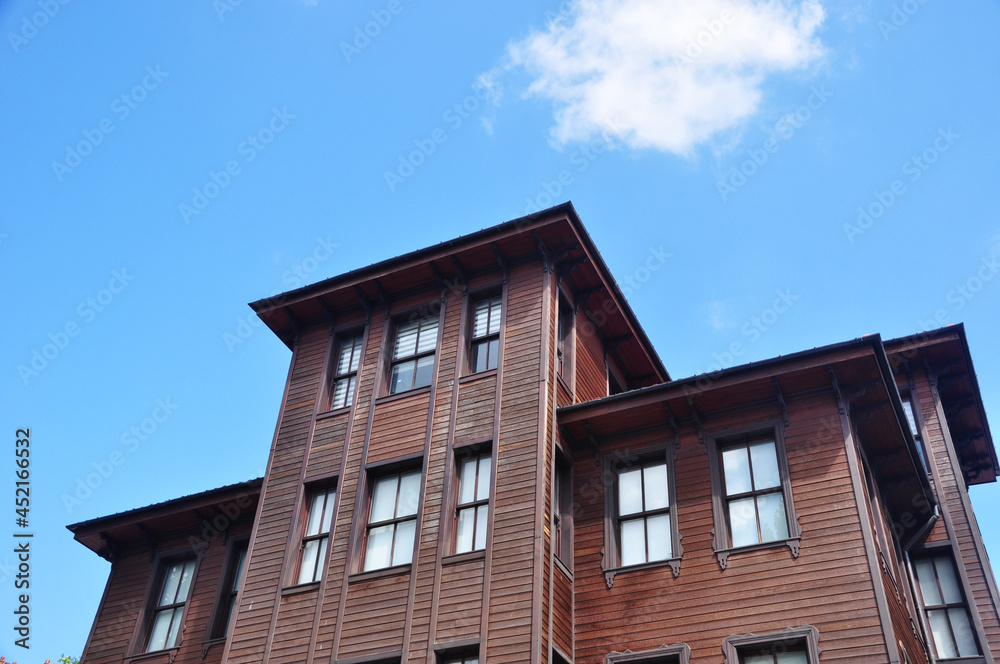 Upper floors of a wooden house. Urban architecture, wooden houses. The house is sheathed with narrow boards.